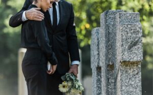 Couple Grieving At A Gravestone Due To Wrongful Death Needs An Attorney